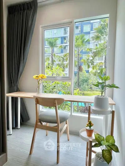 Bright study area with large window overlooking lush greenery, perfect for a serene work environment.