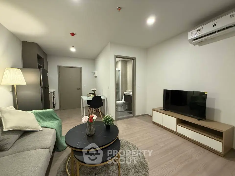 Modern living room with cozy decor and open layout, featuring a sleek TV unit and stylish furniture.
