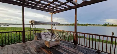 Stunning riverside balcony with wooden deck and cozy seating area.