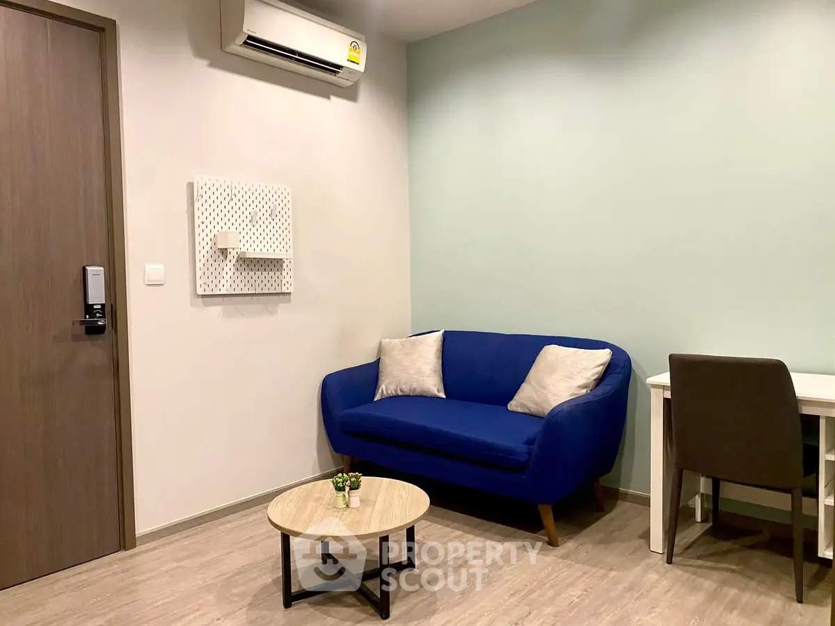 Modern living room with blue sofa and minimalist decor, perfect for cozy relaxation.