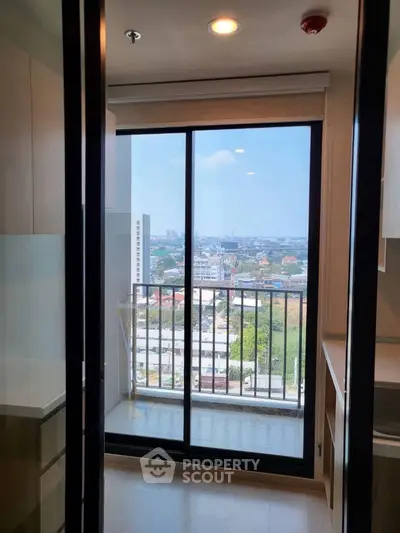Modern apartment balcony with stunning city view and sleek glass doors.