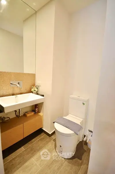 Modern bathroom with sleek design featuring a wall-mounted sink and contemporary toilet.