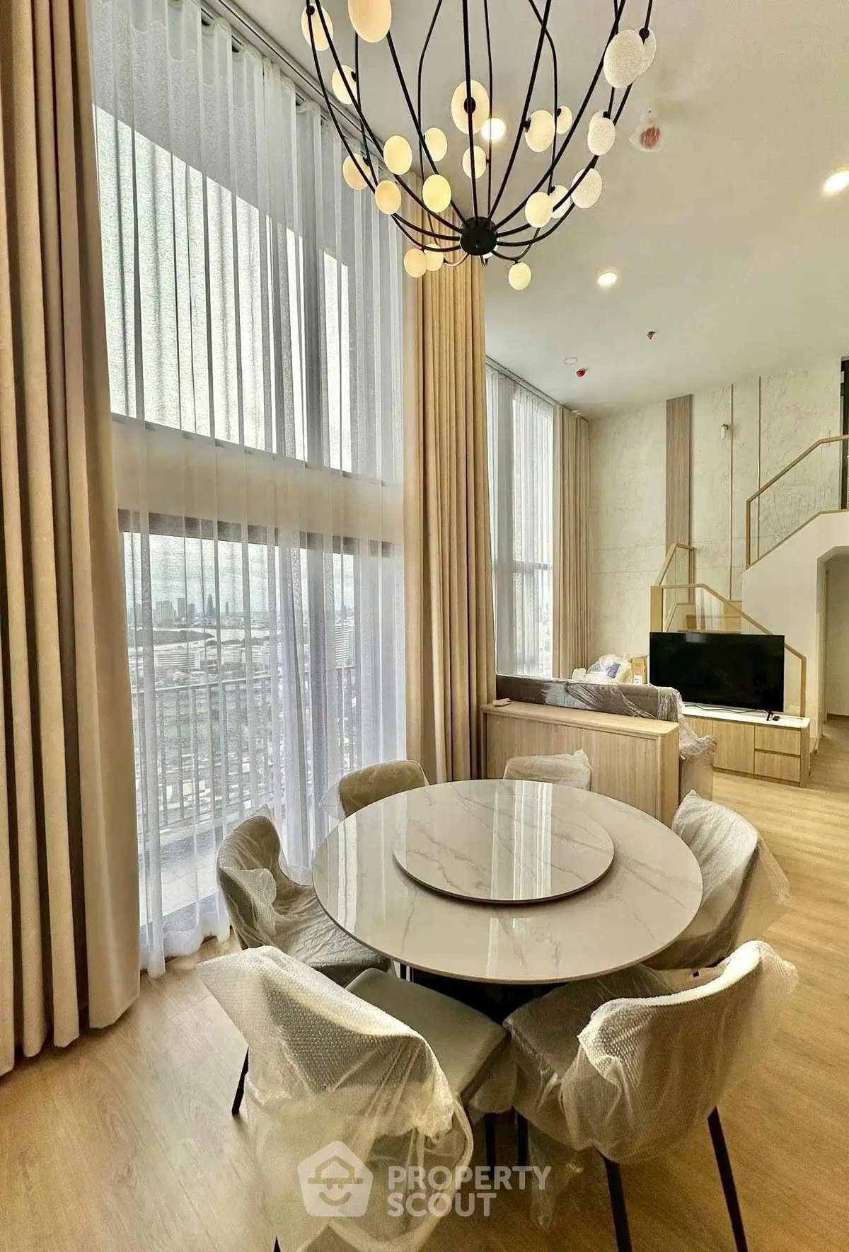 Luxurious modern living room with high ceilings and elegant chandelier