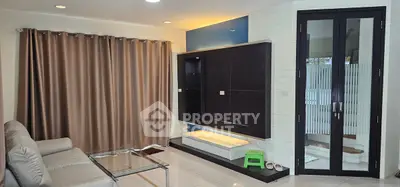 Modern living room with sleek glass table and stylish curtains