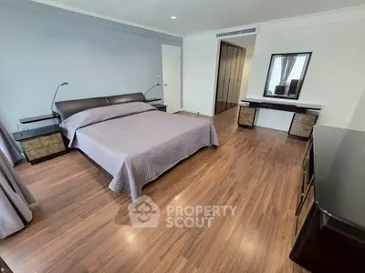 Spacious bedroom with modern decor and wooden flooring