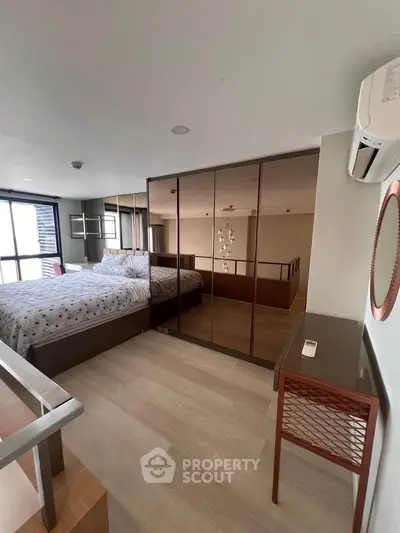 Modern bedroom with mirrored wardrobe and stylish decor in a contemporary apartment.