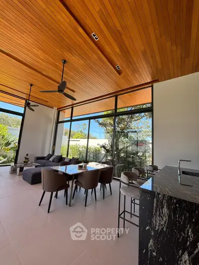 Stunning modern living room with high ceilings and large windows offering a beautiful garden view.