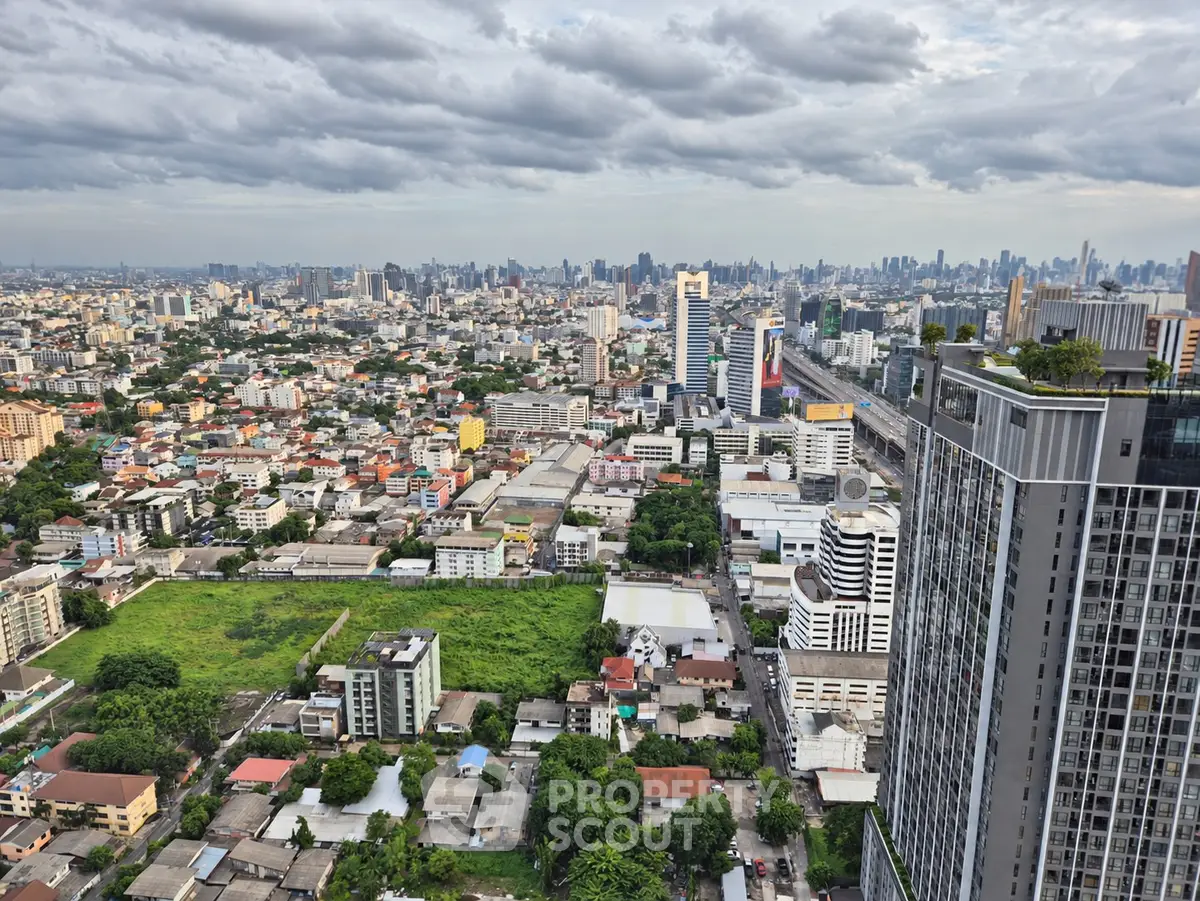 Stunning cityscape view from a high-rise building showcasing urban skyline and lush greenery.
