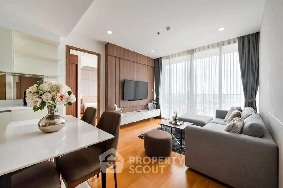 Modern living room with elegant decor and large windows offering natural light.