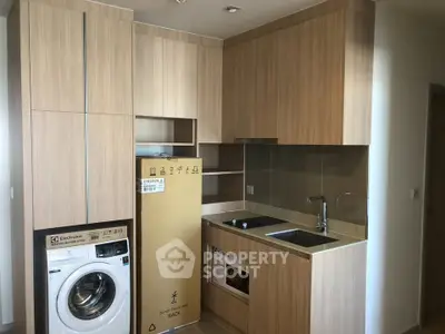 Modern kitchen with wooden cabinetry and built-in appliances in a sleek apartment.