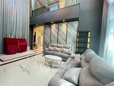 Luxurious living room with plush gray sofas and marble flooring in a modern home.