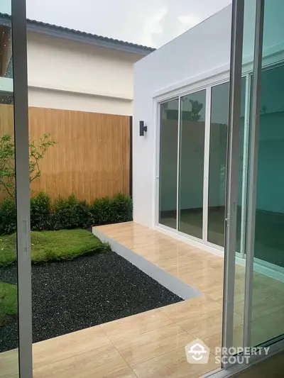 Modern patio with sliding glass doors and minimalist garden design