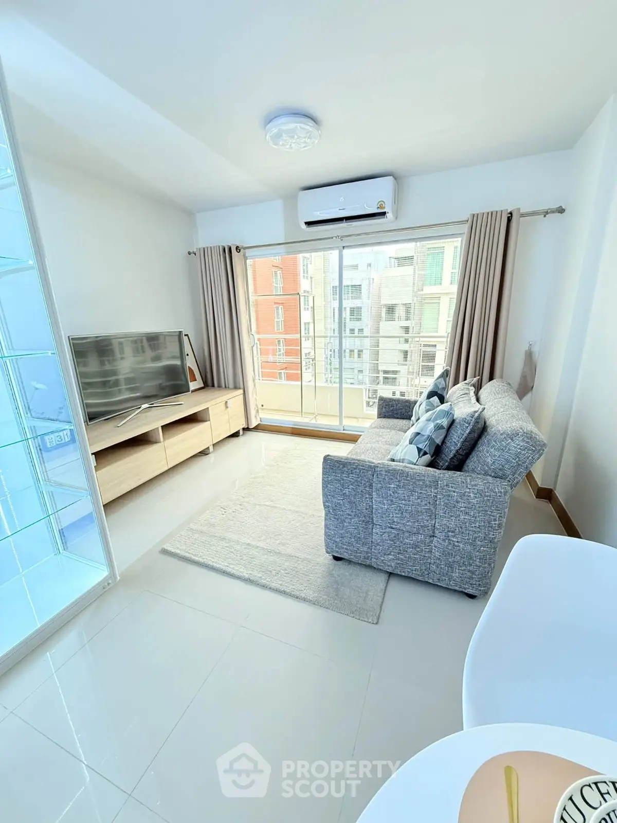 Modern living room with large window and stylish furniture in a bright apartment.