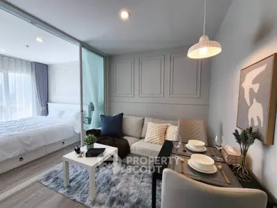 Modern open-plan living room with cozy decor and adjacent bedroom in stylish apartment.