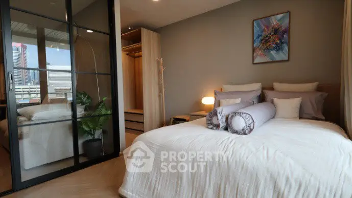 Modern bedroom with stylish decor and city view, featuring a cozy bed and spacious wardrobe.