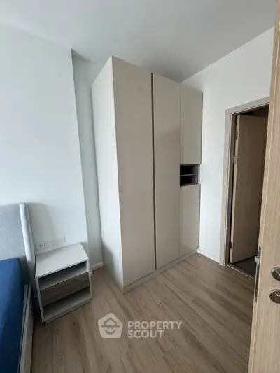 Modern bedroom with sleek wardrobe and wooden flooring