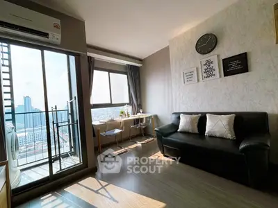 Modern living room with balcony and city view, featuring stylish decor and ample natural light.