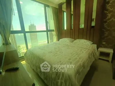 Luxurious bedroom with stunning city and sea view from large windows.