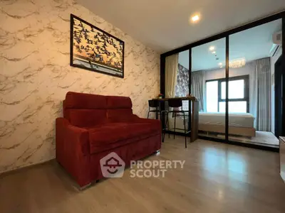 Modern living room with red sofa and glass partition leading to bedroom