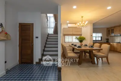 Spacious dining area with elegant chandelier and modern kitchen in open layout