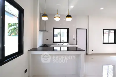 Modern kitchen with sleek black countertops and pendant lighting