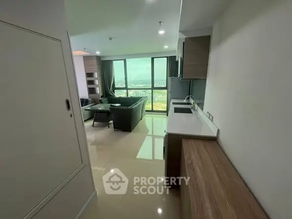 Modern open-layout living room with panoramic city view and sleek kitchen design.