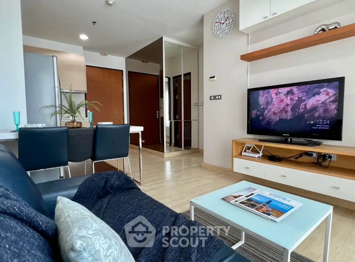 Modern living room with sleek furniture and wall-mounted TV, open layout and stylish decor.