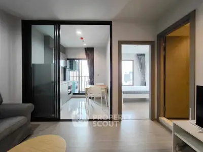 Modern apartment interior with open kitchen and living area, featuring sleek design and natural light.