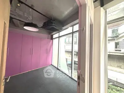 Modern room with vibrant purple storage and large windows for natural light.