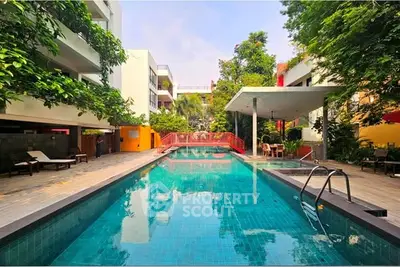 Luxurious residential pool area with lush greenery and modern design.