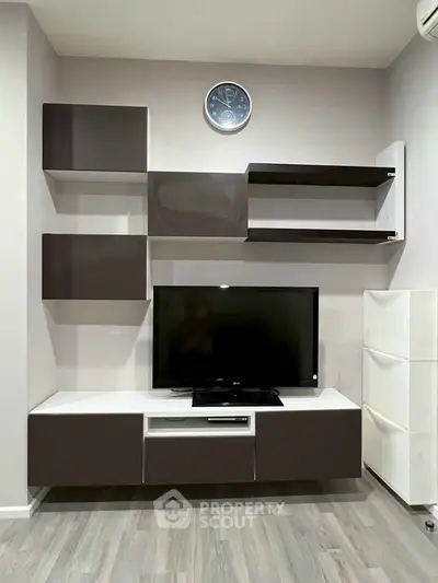 Modern living room with sleek TV unit and wall-mounted shelves, perfect for stylish urban living.