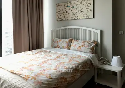 Cozy bedroom with floral bedding and elegant wall art in modern apartment
