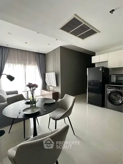 Modern living room with sleek furniture and appliances, featuring a cozy dining area and natural light.