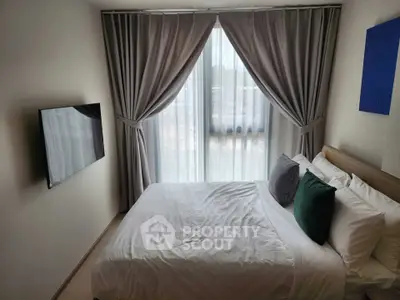 Cozy bedroom with modern decor and large window for natural light.