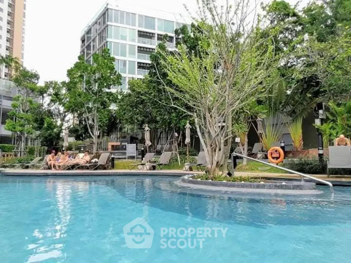 Luxurious residential pool area with lush greenery and modern architecture.
