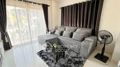 Stylish living room with modern gray sofa, chic curtains, and elegant decor in a bright, inviting space.