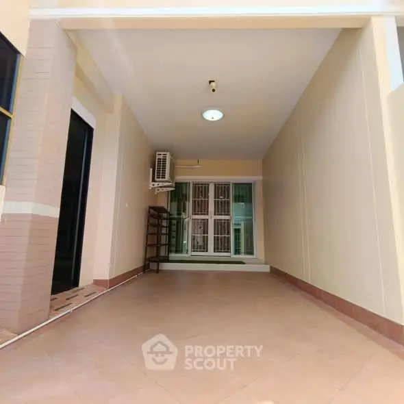 Spacious covered parking area with tiled flooring and natural light.