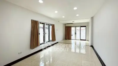 Spacious unfurnished living room with large windows and tiled flooring