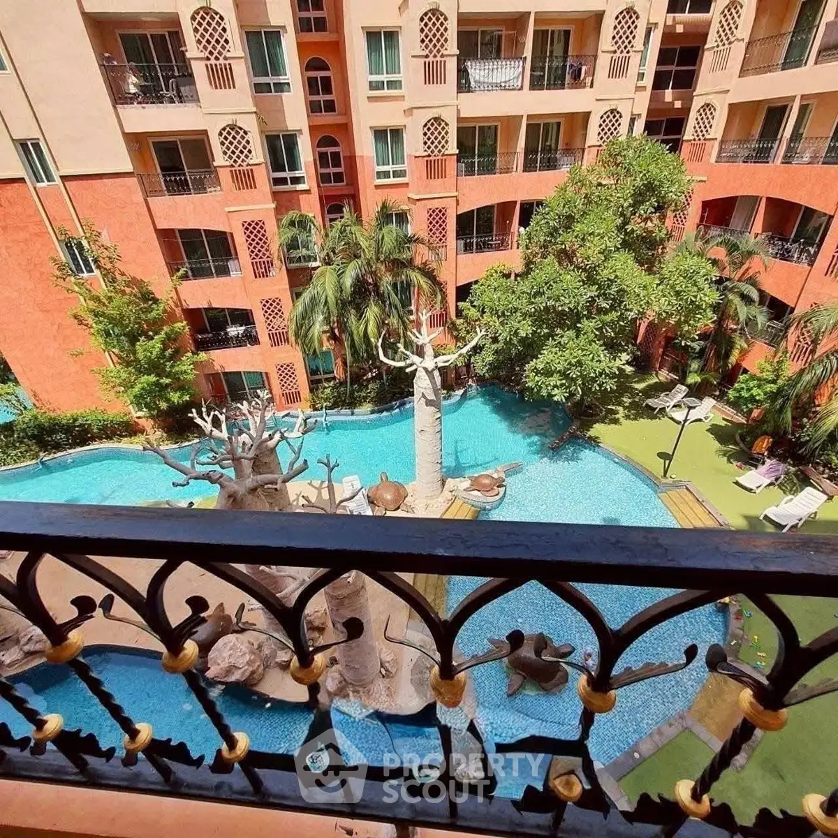 Stunning view of a luxurious apartment complex with a beautiful pool and lush greenery.