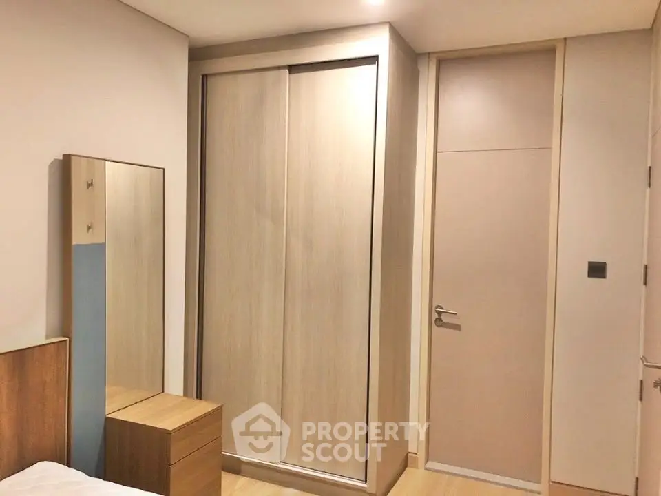 Modern bedroom with sleek wooden wardrobe and minimalist decor