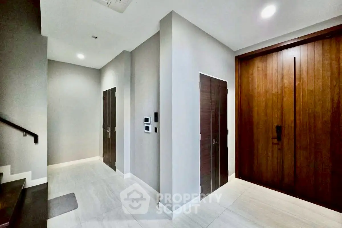 Modern apartment entrance with sleek wooden doors and minimalist design.