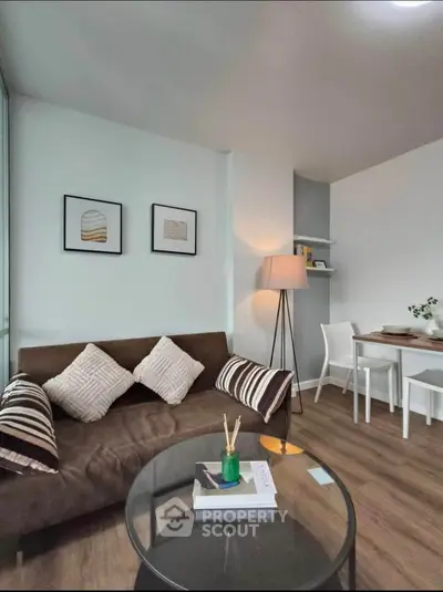 Modern living room with cozy sofa and dining area, stylish decor and wooden flooring.
