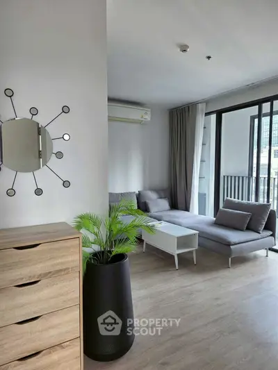 Modern living room with stylish decor and large windows offering natural light.