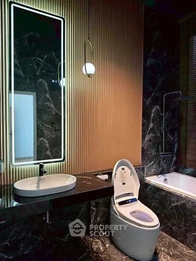 Luxurious modern bathroom with marble walls, smart toilet, and elegant lighting.