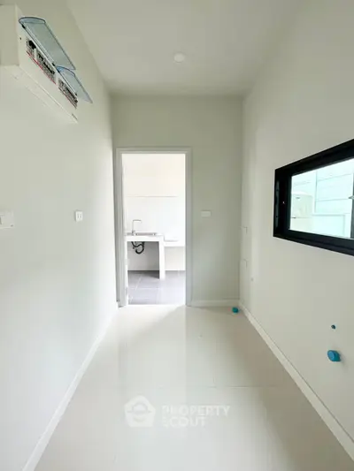 Modern utility room with sleek white tiles and ample natural light