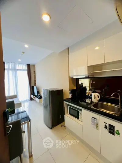 Modern open-layout kitchen with sleek appliances and cozy living area.