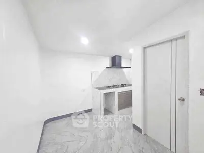 Modern minimalist kitchen with sleek gas stove and marble flooring