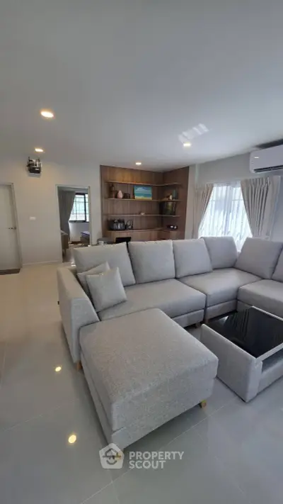 Spacious modern living room with stylish gray sectional sofa and elegant decor