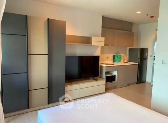 Modern studio apartment with sleek kitchen and entertainment area