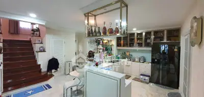 Spacious kitchen with modern design and open layout, featuring a stylish staircase and elegant decor.